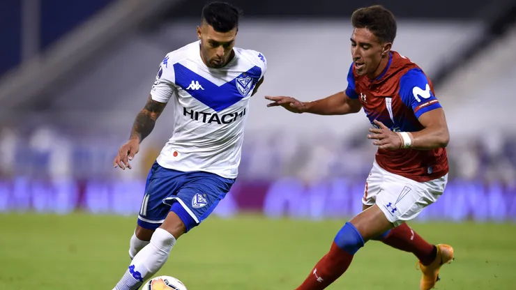 Lucas Janson lucha una pelota con Diego Valencia. ¿Será refuerzo de la U. de Chile el jugador de Vélez Sarsfield?