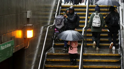 Personas ingresando al Metro de Santiago en medio de la lluvia (2021)