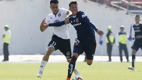 Pablo Parra disputa un balón con Gabriel Suazo en un Superclásico. Pronto será oficializado como incorporación de Colo Colo.