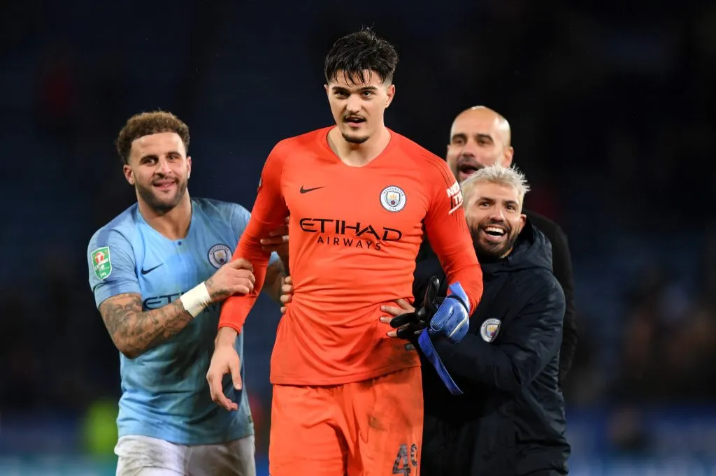 Kyle Walker, Sergio Agüero y Pep Guardiola agasajan a Arijanet Muriç después de que el meta kosovar fue figura en una tanda de penales ante el Leicester City por la Carabao Cup. (Shaun Botterill/Getty Images).