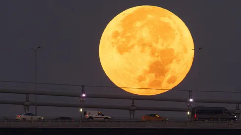 Estanbul, Turquía - 31 de agosto: Autos cruzan el Puente de los Mártires mientras la Super Luna Azul se pone detrás.