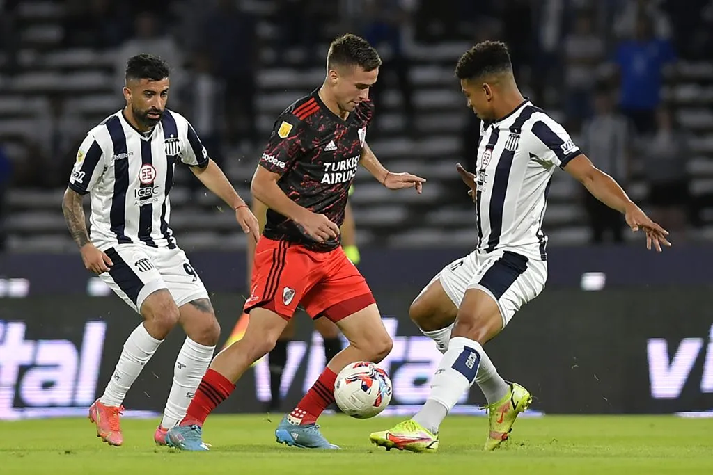 Michael Santos (con barba) y Diego Valoyes intentan quitarle el balón a Agustín Palavecino en un partido entre River Plate y Talleres de Córdoba. (Hernan Cortez/Getty Images).