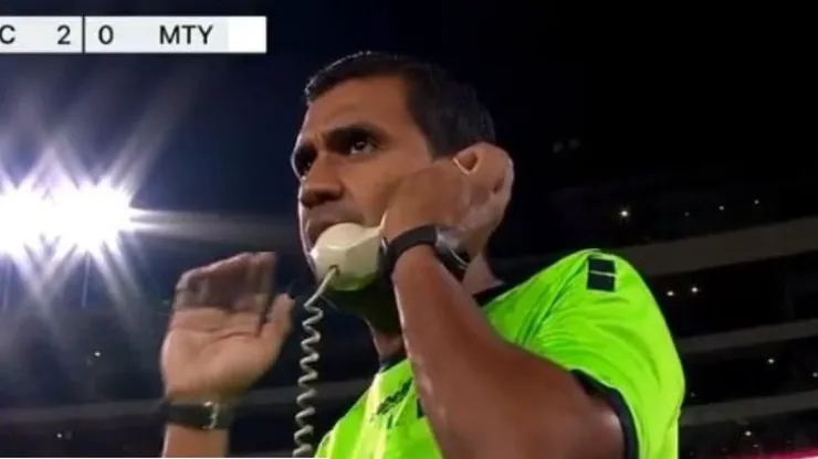 Árbitro atendiendo al VAR