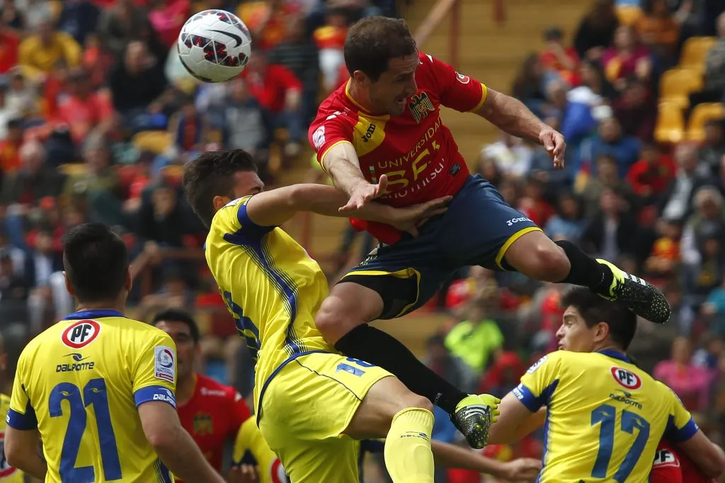 Juan Pablo Gómez disputa un balón aéreo con Nicolás Berardo. Fernando Manríquez (21) mira todo atentamente. (Felipe Zanca/Photosport).