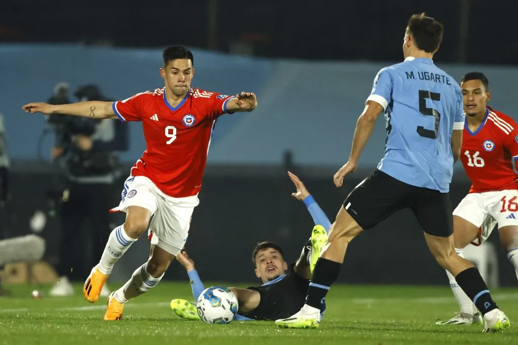 Alexander Aravena en acción ante Uruguay en el mítico estadio Centenario ante la marca de Manuel Ugarte, volante del PSG de Francia. (Marcelo Hernández/Photosport).