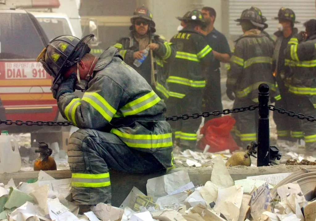 El bombero Gerard McGibbon, de la autobomba 283 de Brownsville, Brooklyn, reza tras el derrumbe de los edificios del World Trade Center el 11 de septiembre de 2001 | Foto: Getty Images