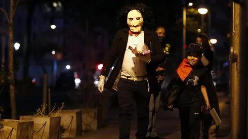 Niños disfrutan la noche de Halloween pidiendo dulces junto a sus padres en la comuna de Santiago.