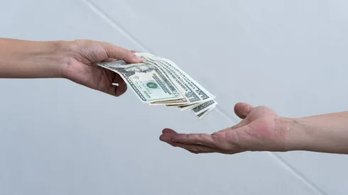Una persona entrega dinero a otra