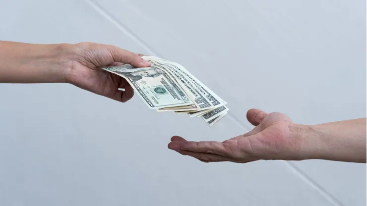 Una persona entrega dinero a otra