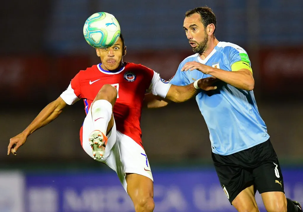 Diego Godín marca a Alexis Sánchez en el estadio Centenario. (Fernando González/Photosport).
