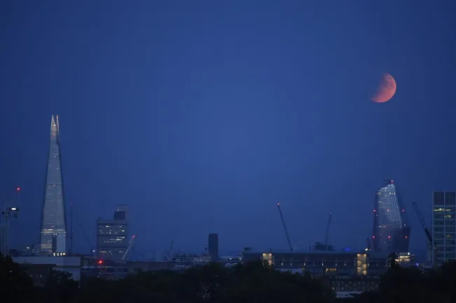 Un eclipse lunar parcial aparece sobre el horizonte el 16 de julio de 2019 en Londres, Inglaterra | Foto: Getty Images