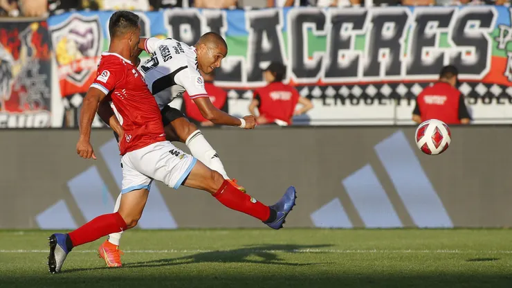 Leandro Benegas remata ante la marca de Christian Vilches en un duelo entre Colo Colo y Magallanes. ¡Hay fecha para el duelo pendiente entre estos equipos!