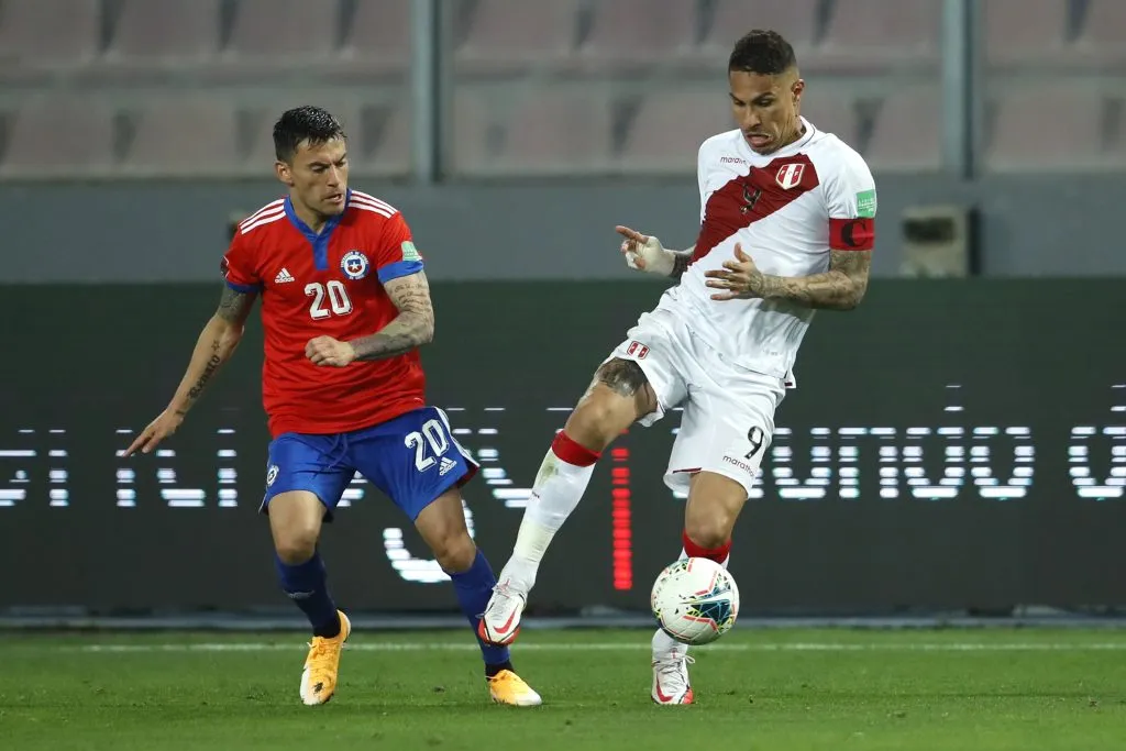LIMA, PERU – OCTOBER 07:  Paolo Guerrero of Peru fights for the ball with Charles Aránguiz of Chile during a match between Peru and Chile as part of South American Qualifiers for Qatar 2022 at Estadio Nacional on October 07, 2021 in Lima, Peru. (Photo by Daniel Apuy/Getty Images)