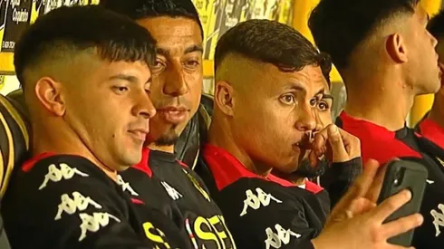 Montecinos y Tiznado mirando el celular en la banca