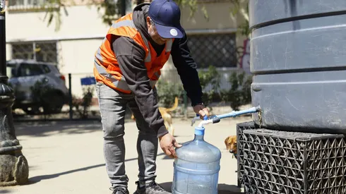 Una persona llega hasta un punto de abastecimiento de la comuna de Santiago, producto del megacorte de agua.