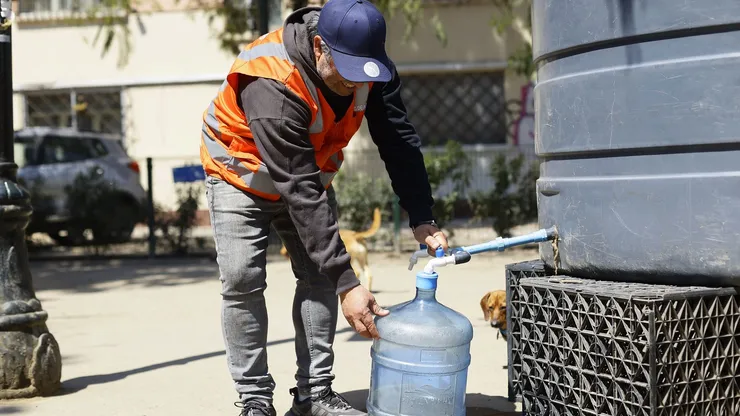 Una persona llega hasta un punto de abastecimiento de la comuna de Santiago, producto del megacorte de agua.