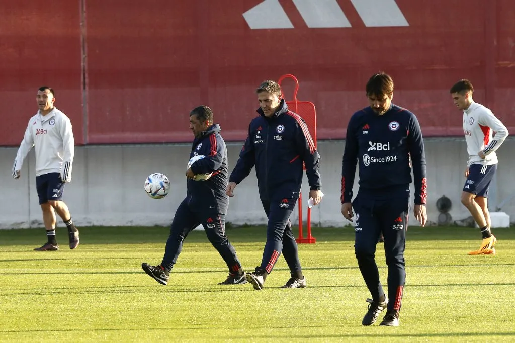 Wilson Vásquez domina un balón y lleva otro debajo del brazo, muy cerca de Eduardo Berizzo. (Javier Salvo/Photosport).