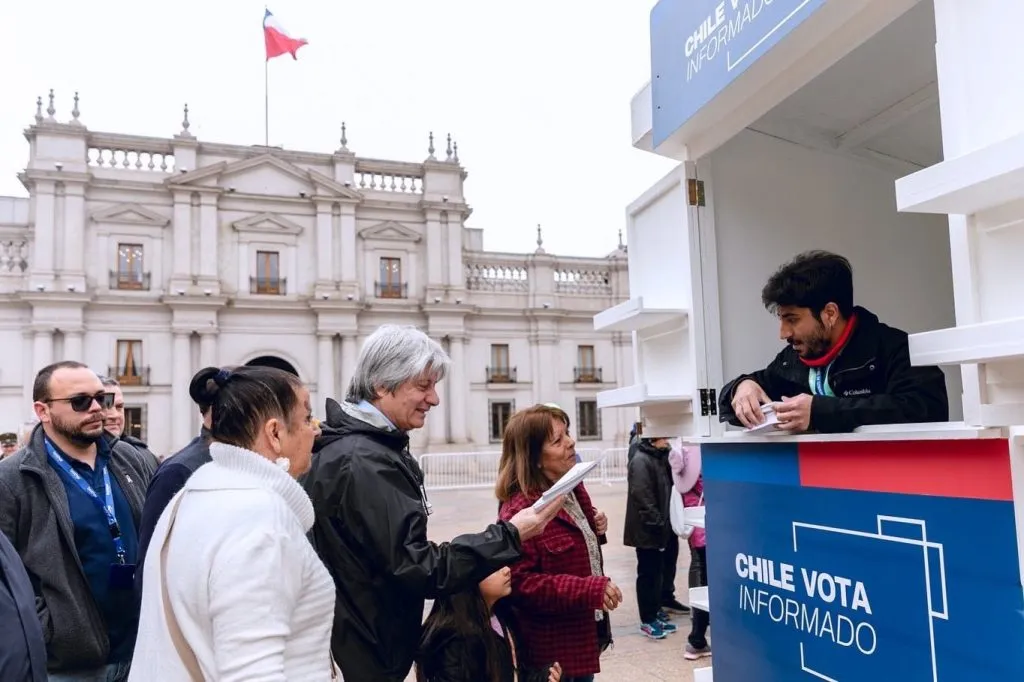 Entregan copias de la propuesta de nueva Constitución en el kiosko de la Plaza de la Constitución.
