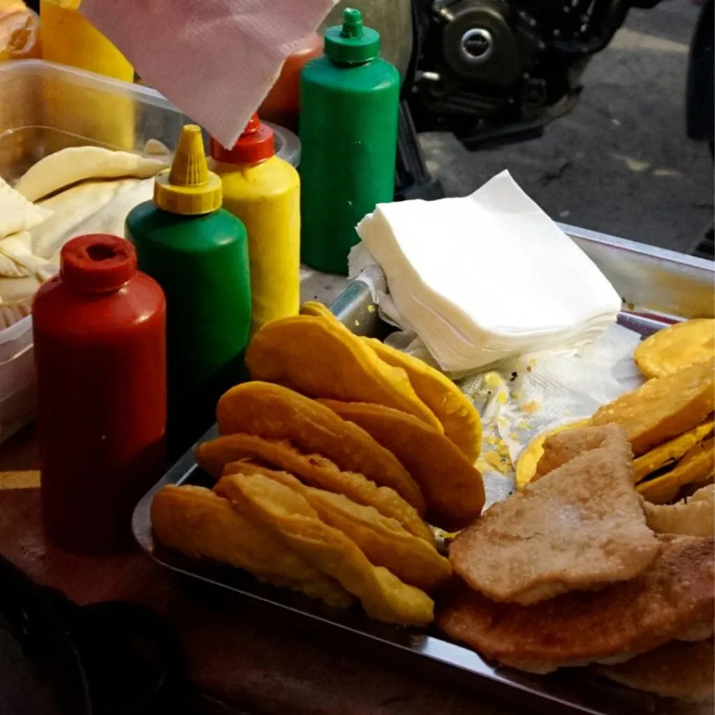 Carrito callejero vende sopaipillas y ofrece la opción de acompañarla con salas como mayonesa, ketchup y mostaza.