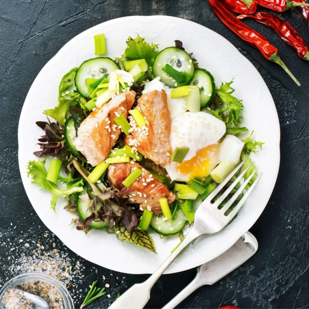 Ensalada con pesto, salón, pepino y hojas verdes