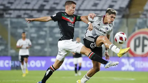 Agustín Farís disputa un balón con Carlos Palacios en un partido entre Colo Colo y Palestino.
