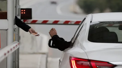 SConductor de un vehículo paga un peaje en la caseta de una autopista.