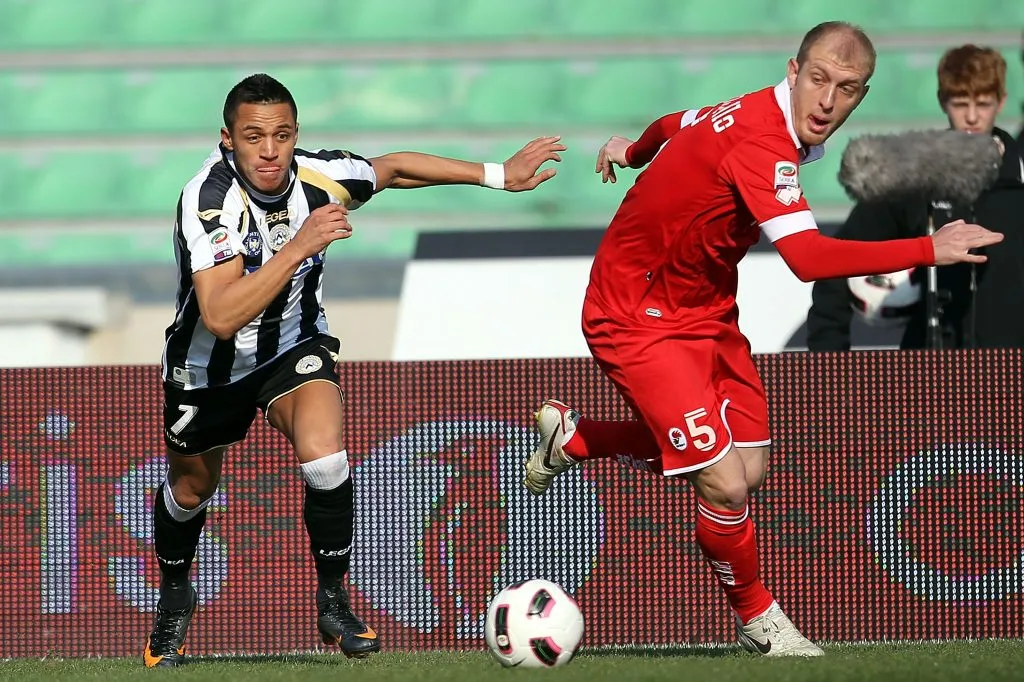 Alexis Sánchez hace de las suyas en el Udinese ante la marca de Andrea Masiello. (Gabriele Maltinti/Getty Images).