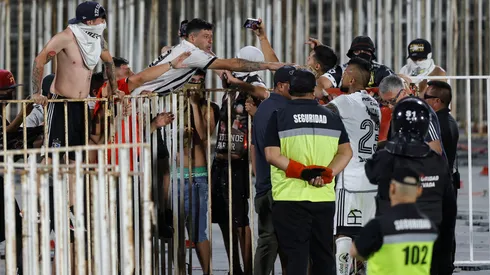 Arturo Vidal tratando de calmar a los "hinchas" de Colo Colo en el Estadio Nacional.
