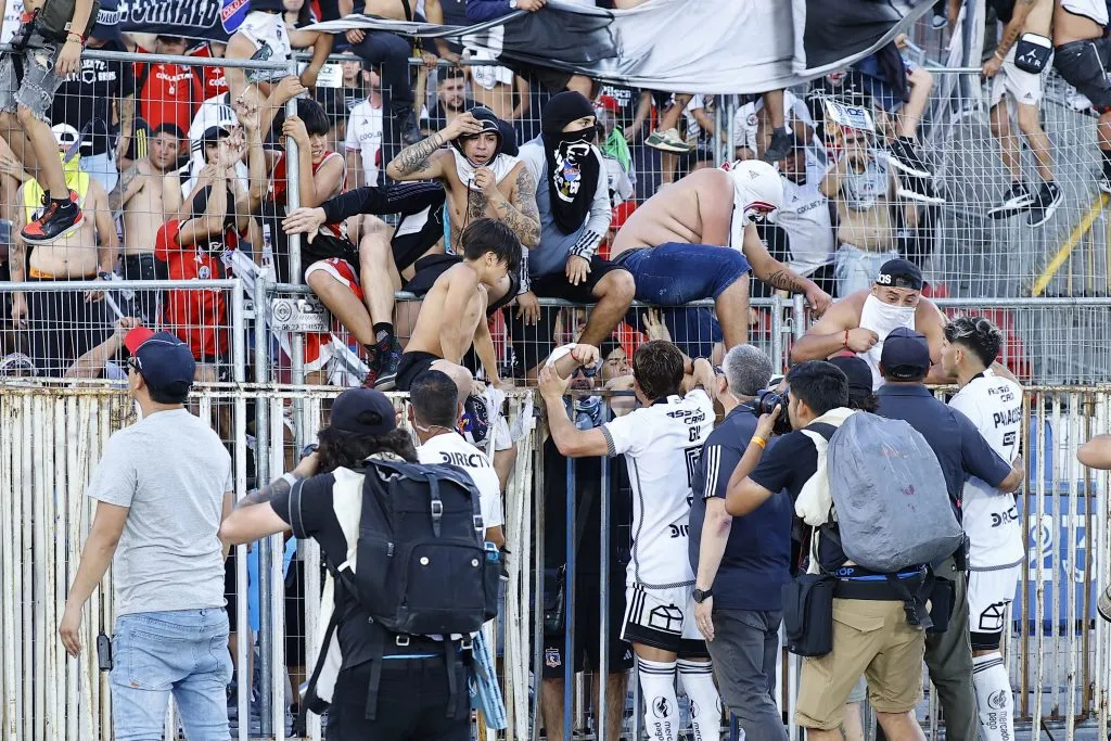 Carlos Palacios y Leonardo Gil se acercaron a intentar frenar a los hinchas en el entretiempo. (Marcelo Hernández/Photosport).