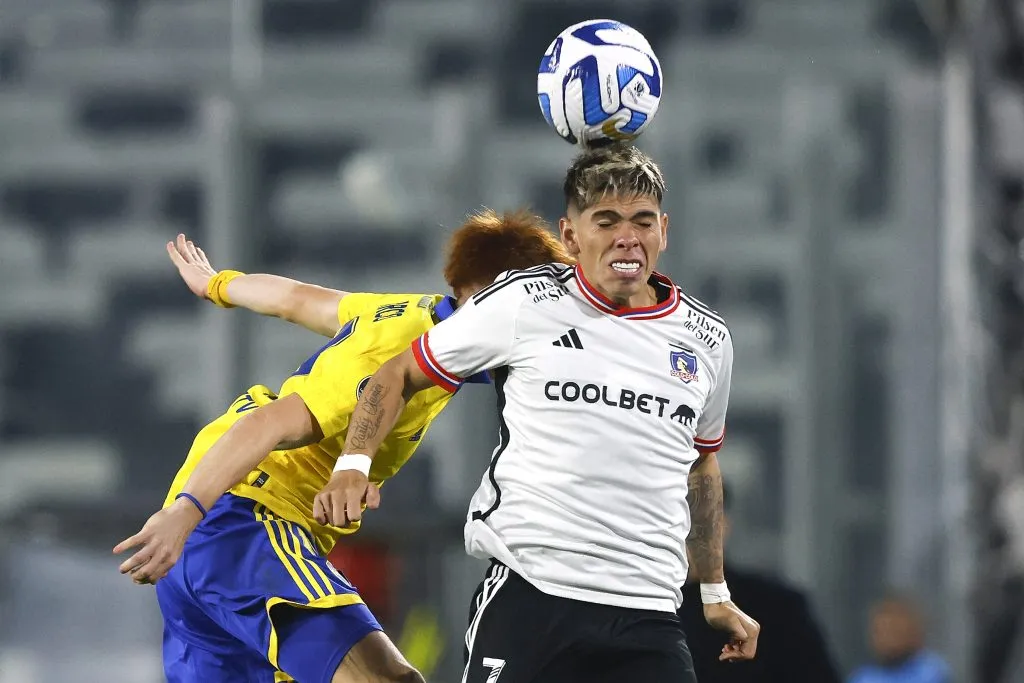 Carlos Palacios lucha un balón aéreo con Valentín Barco. (Felipe Zanca/Photosport).
