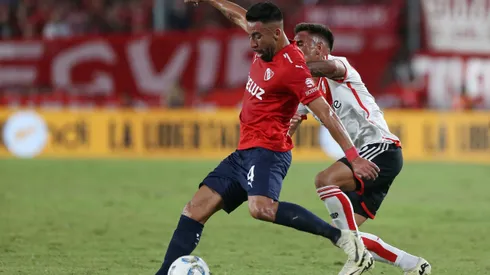 Mauricio Isla domina el balón ante la marca de Enzo Díaz en un partido entre Independiente y River Plate.