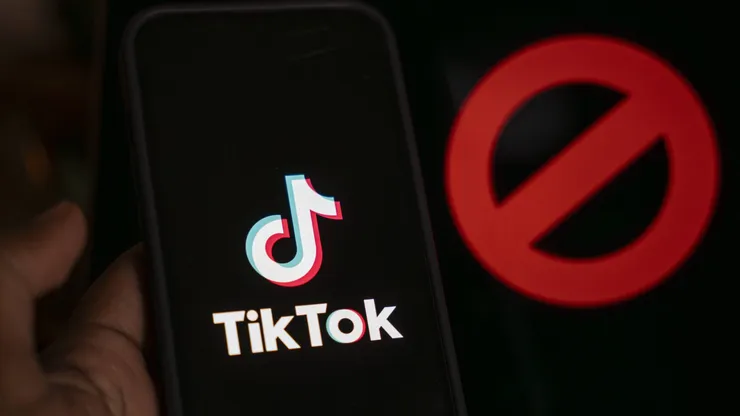 April 25, 2024: In this photo illustration, logo of Tiktok is displayed on mobile phone screen next to ban sign, in Guwahati, India 25 April 2024. US President Joe Biden signs law to ban Chinese-owned TikTok unless sold to US company. - ZUMAt232 20240425_zip_t232_002 Copyright: xDavidxTalukdarx