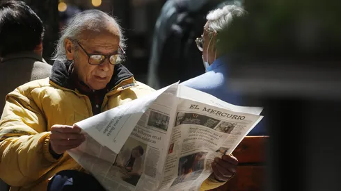 Adulto mayor leyendo un diario: Vida diaria en Santiago
