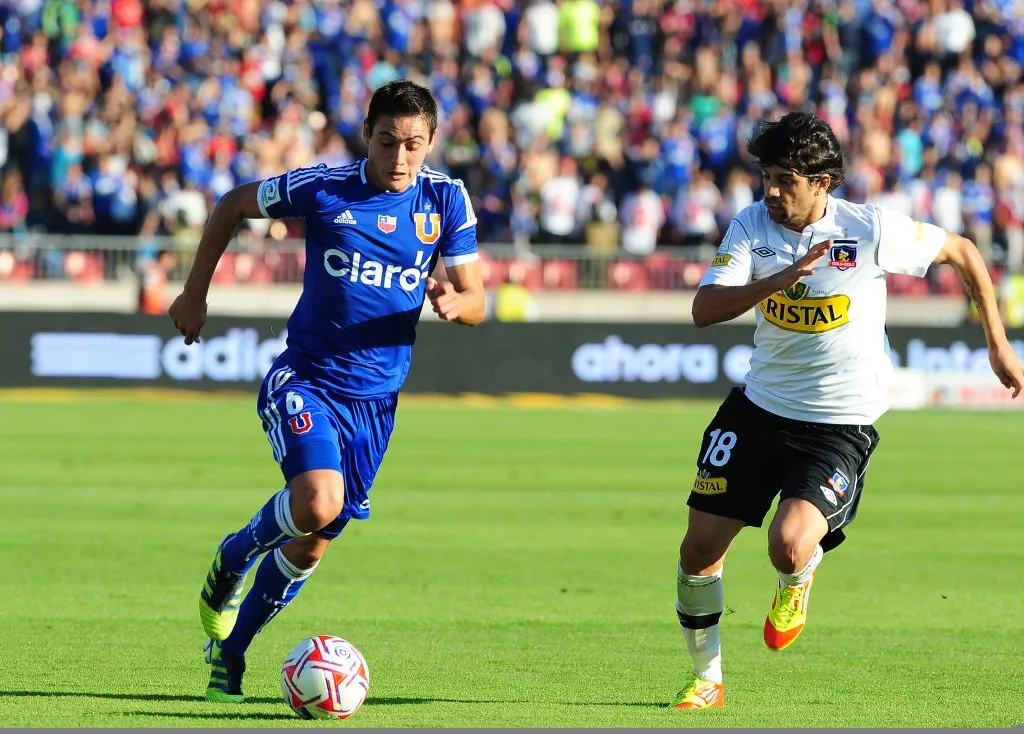 Lucas Wilchez en acción ante Matías Rodríguez en un Superclásico.  (David Vásquez | Photosport).