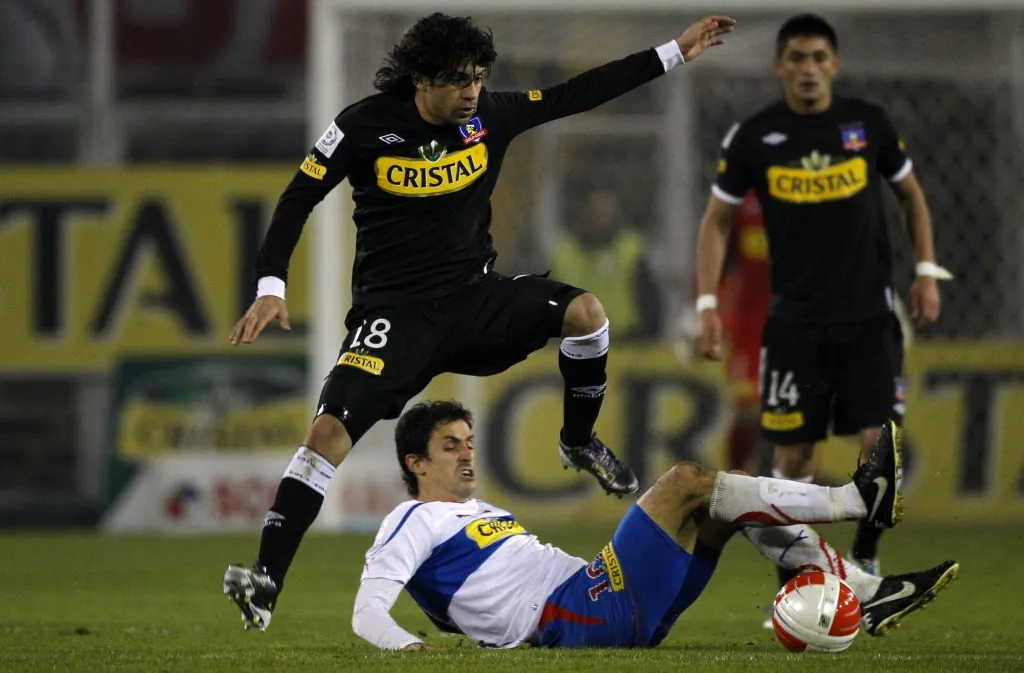 Lucas Wilchez en acción ante Universidad Católica. Disputa un balón con Milovan Mirosevic ante la mirada del Chino Millar. (ANDRES PINA/PHOTOSPORT).