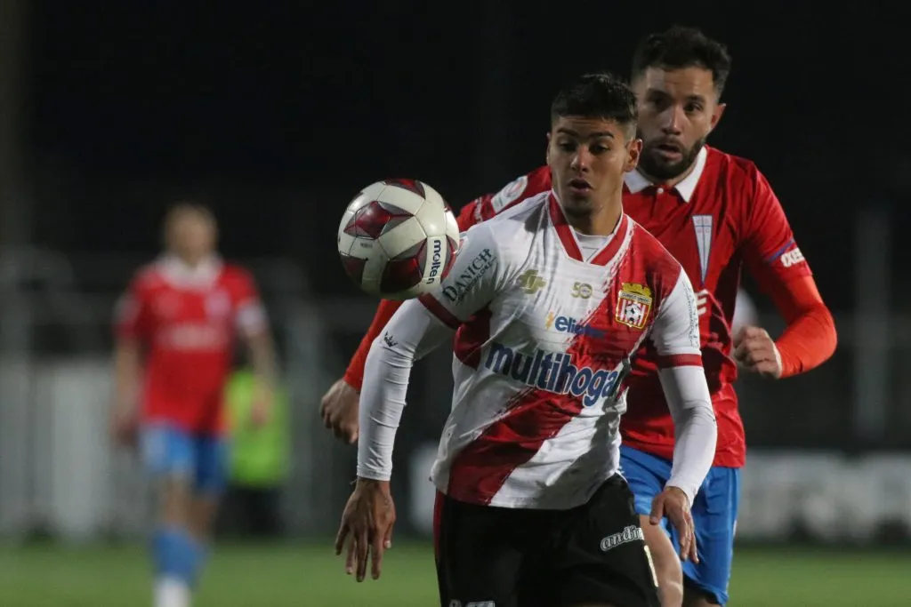 Yerko Leiva aguanta la marca de Eugenio Mena en un partido entre Curicó Unido y la UC en el estadio La Granja, (Jorge Loyola/Photosport).