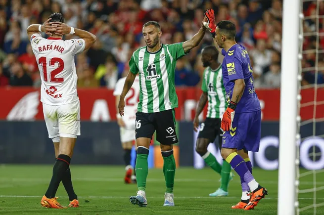 Pezzella felicita a Bravo en un clásico ante el Sevilla. (Antonio Pozo | Imago).