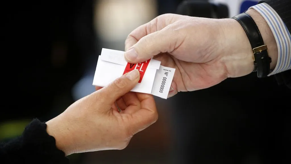 Una persona recibe un voto antes de votar
