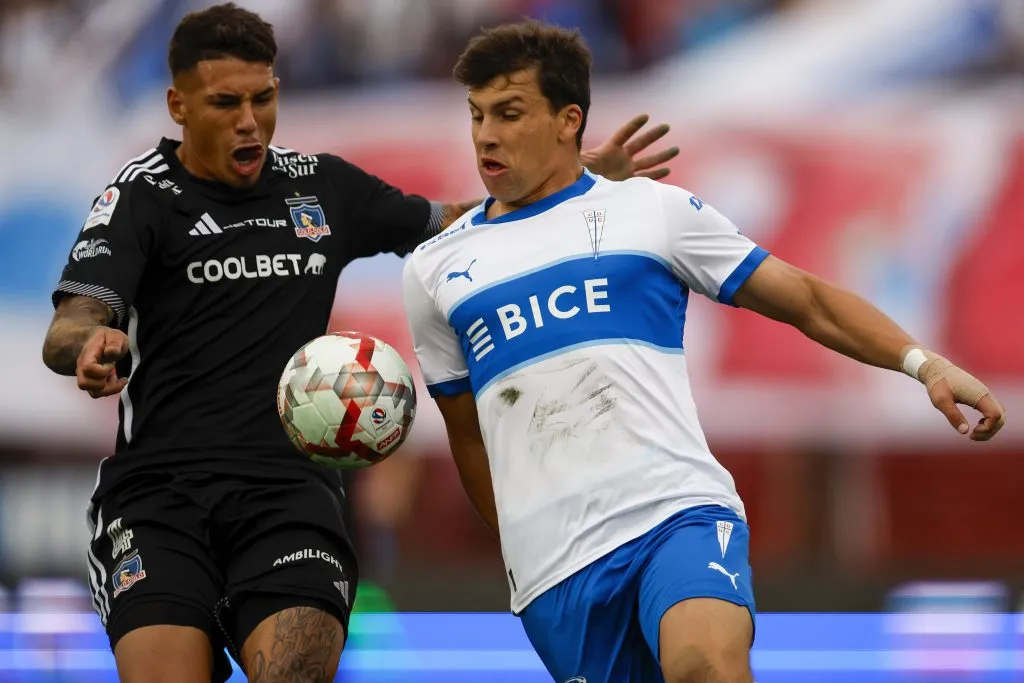 Alan Saldivia lucha un balón contra Gonzalo Tapia en el clásico ante la Católica. (Andrés Piña/Photosport).