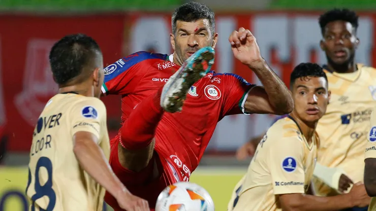 Gigliotti pelea el balón ante los jugadores de Universidad Católica.