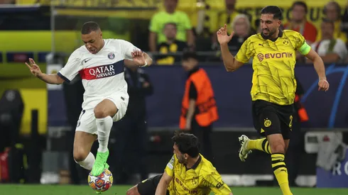 Mbappé lucha contra dos jugadores de Borussia Dortmund.