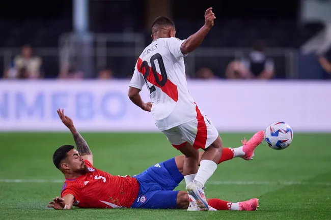 Paulo Díaz le quita una pelota a Edison Flores. (Jose Luis Melgarejo/Mexsport/Photosport).