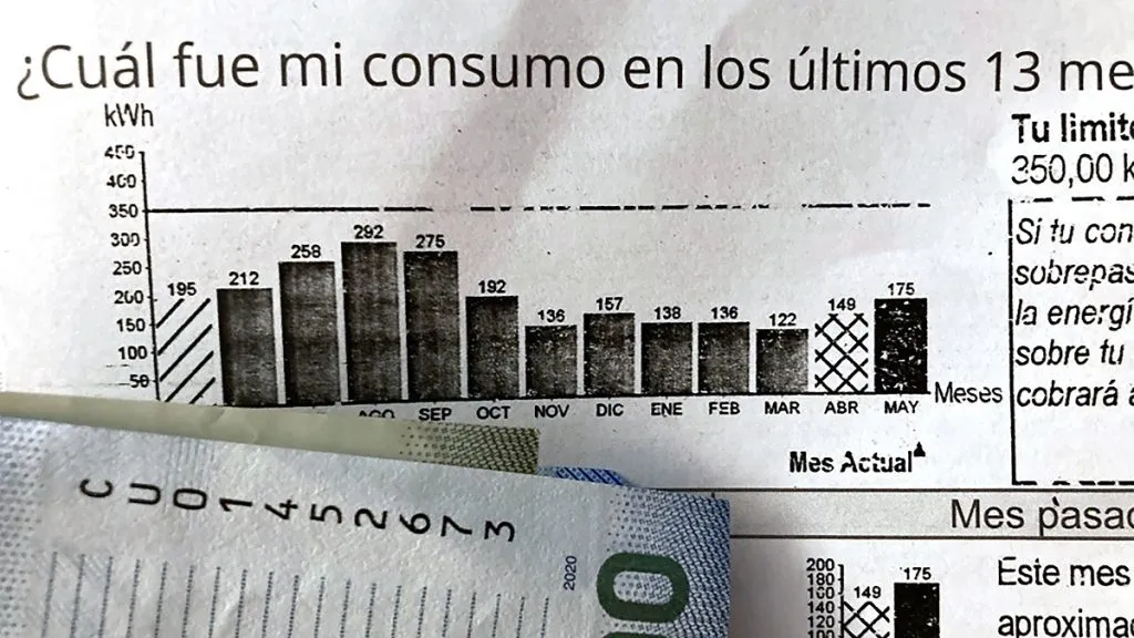 Cuenta de la luz junto con un billete de $10.000