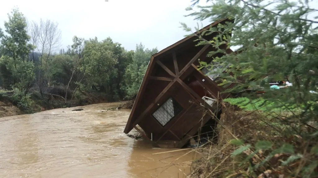 Una vivienda ubicada en la ribera del estero Coyanco está a punto de caer a sus aguas durante el sistema frontal.