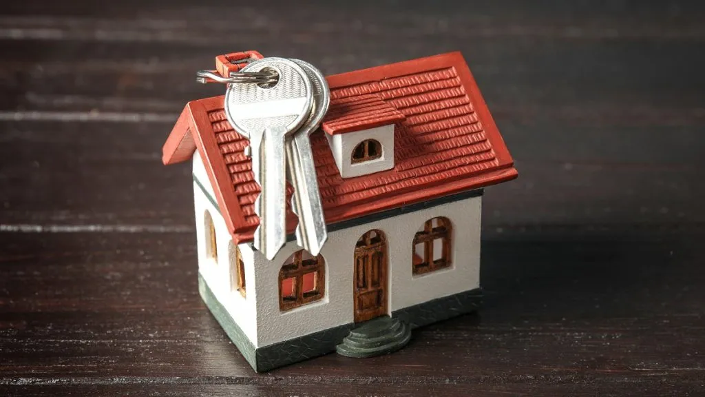 Una casa miniatura y una llaves.