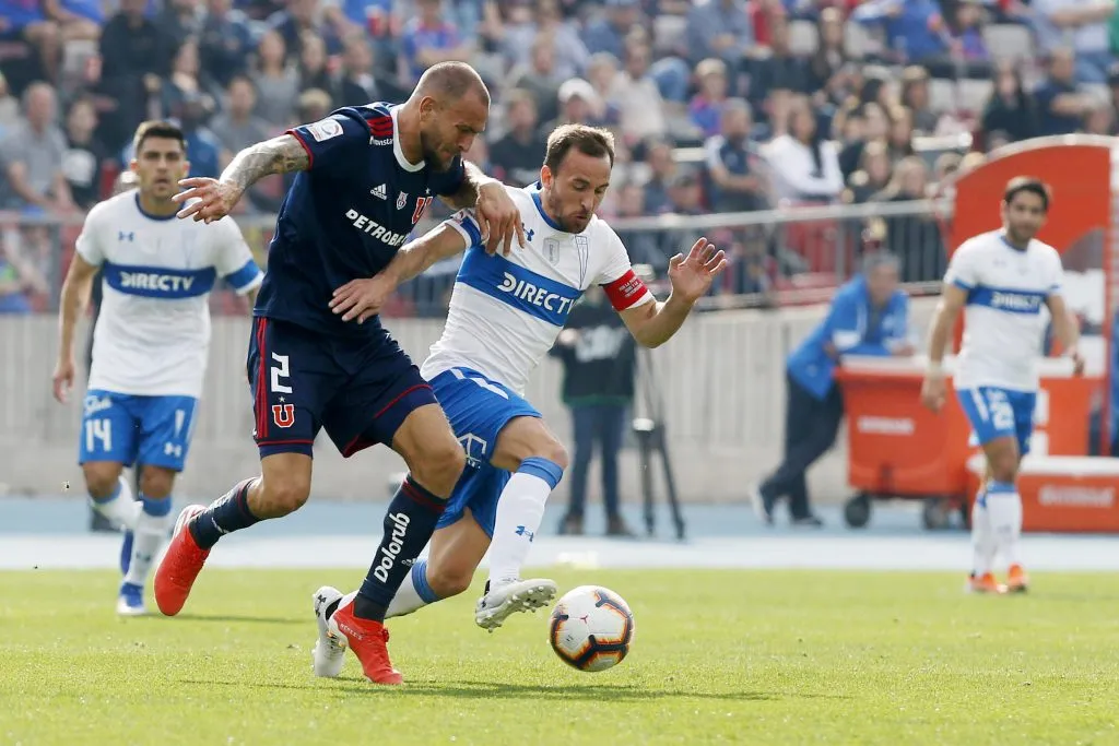 Lucas Aveldaño en acción durante un Clásico Universitario ante José Pedro Fuenzalida. (Ramon Monroy/Photosport).