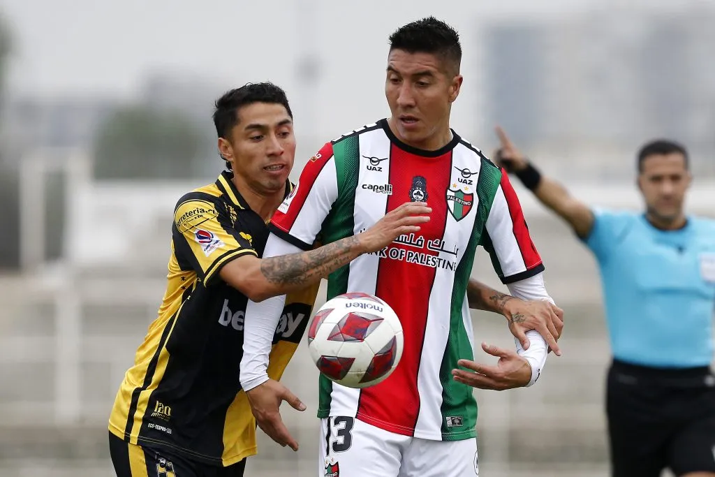 Luciano Cabral lucha con Cristian Suárez en un duelo entre Palestino y Coquimbo Unido. (Javier Salvo/Photosport).