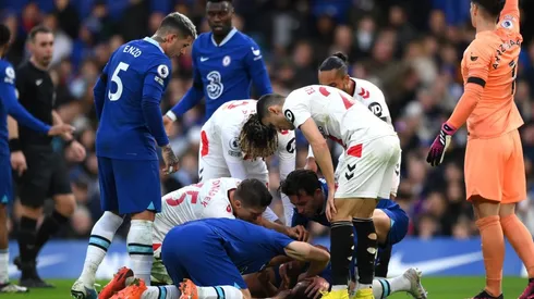 César Azpilicueta desplomado en el piso mientras sus compañeros piden asistencia