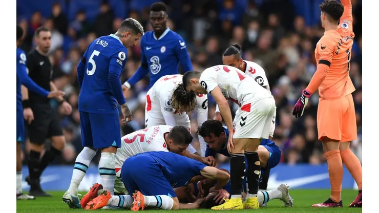 César Azpilicueta desplomado en el piso mientras sus compañeros piden asistencia