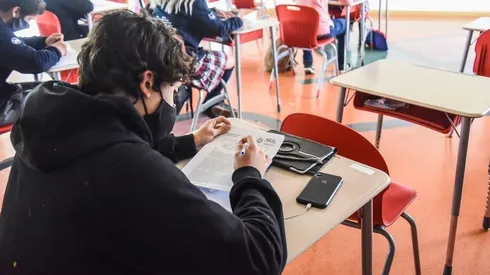 Estudiantes al interior de una sala de clases.